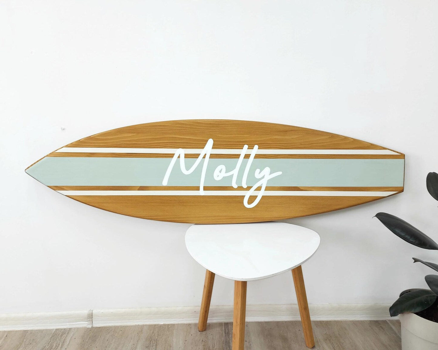 Personalized wooden surfboard name sign hanging in nursery room