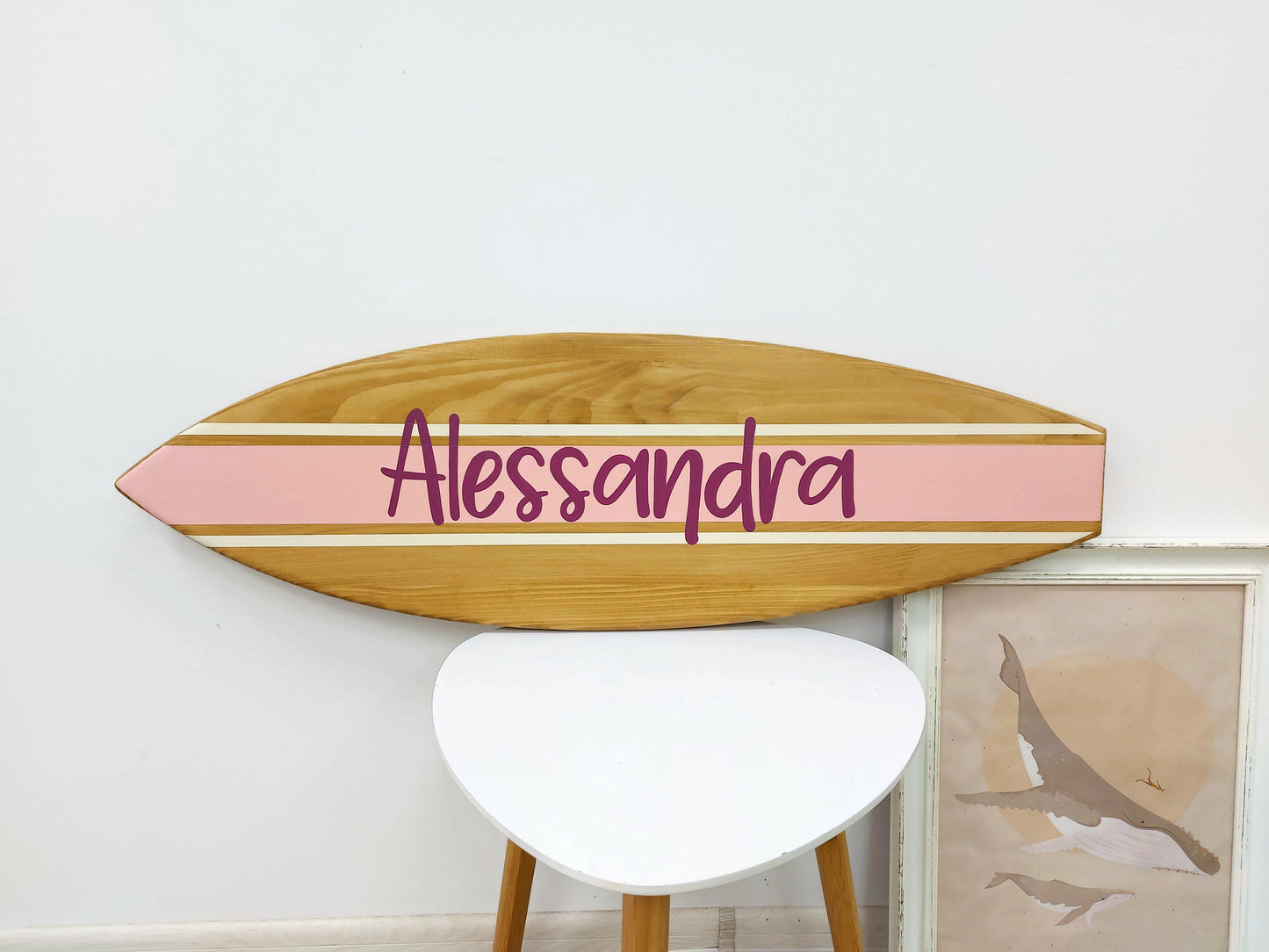 Handcrafted nursery name sign in surfboard shape on white wall