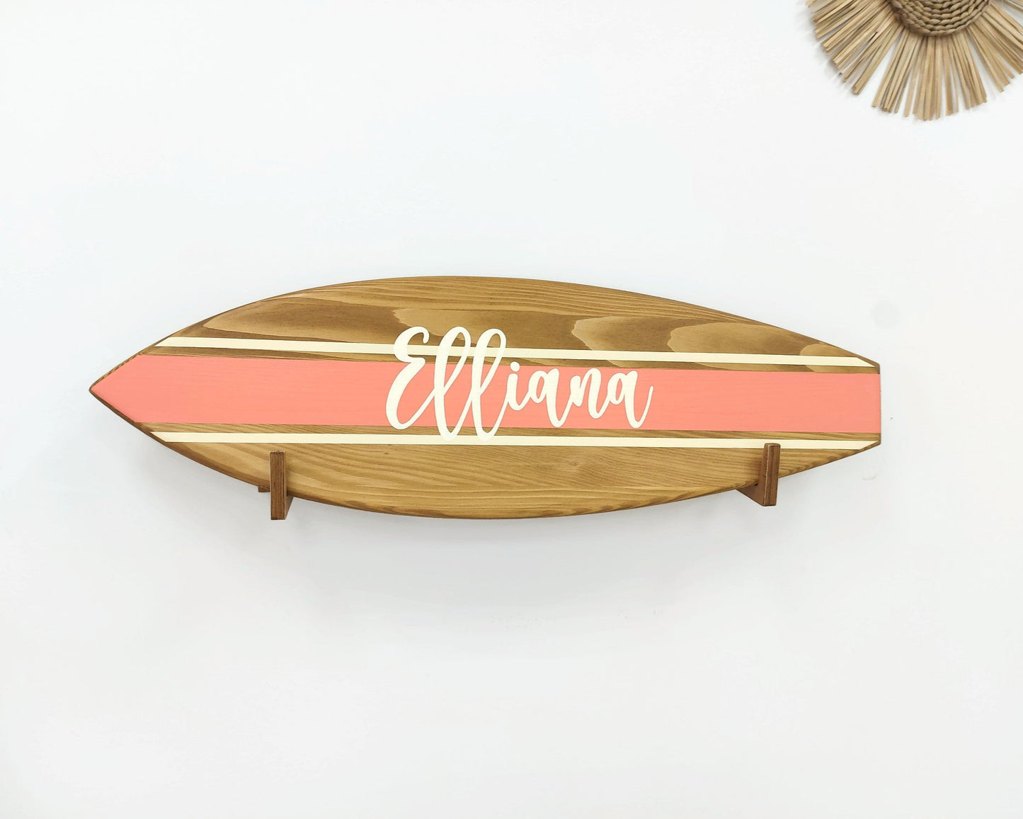 Wooden name sign hanging above crib in beach-themed nursery