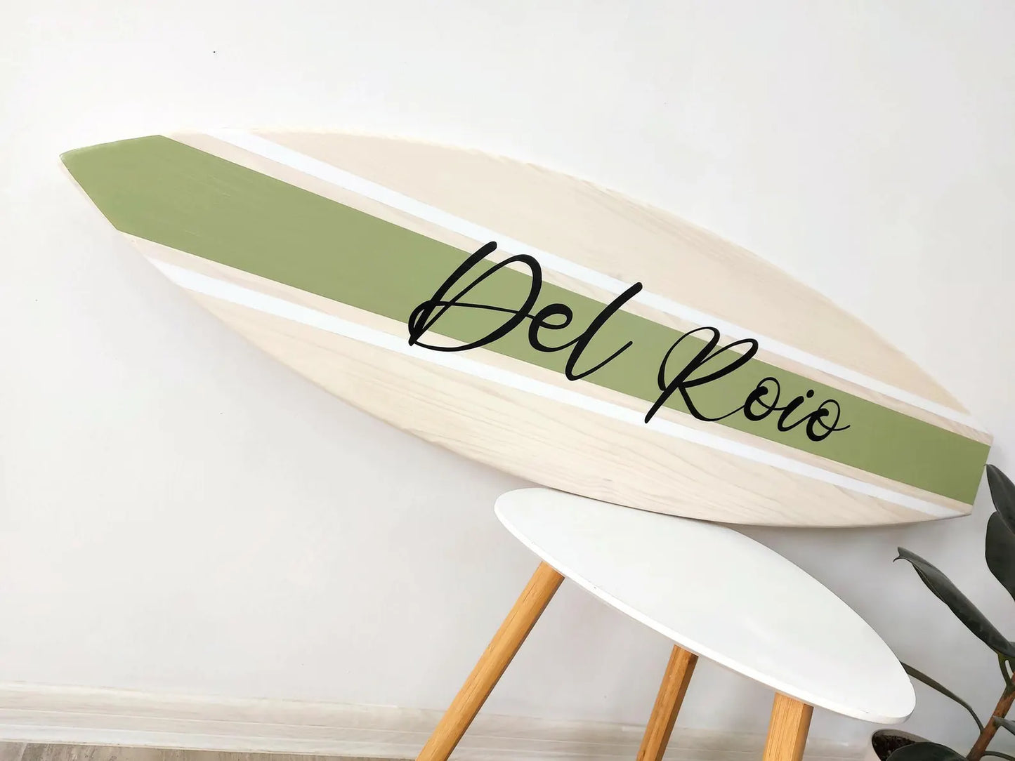 Decorative surfboard name sign with 'Del Roio' branding on a white background