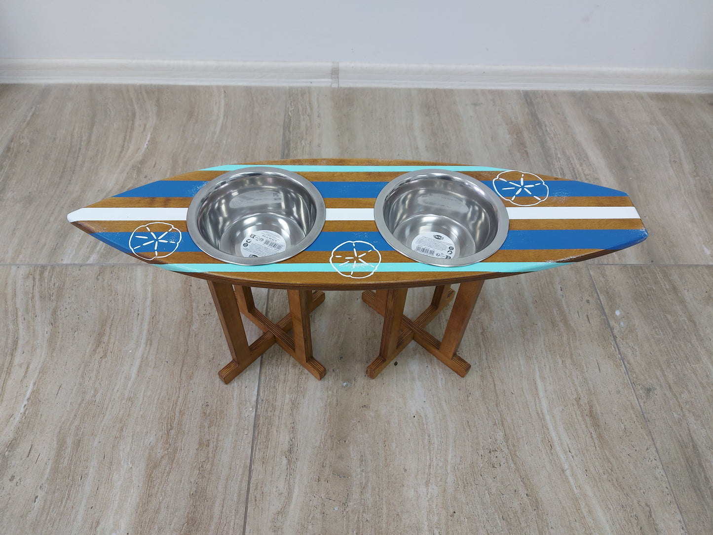 Wooden bowl holder in surfboard shape holding stainless pet bowls
