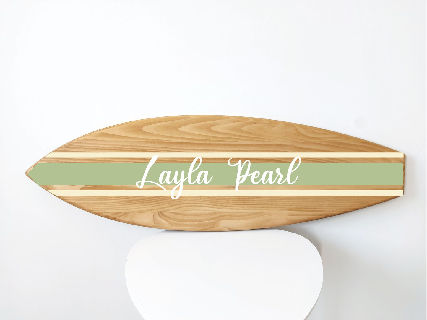 Wooden surfboard-shaped sign with 'Layla Pearl' text on a white background
