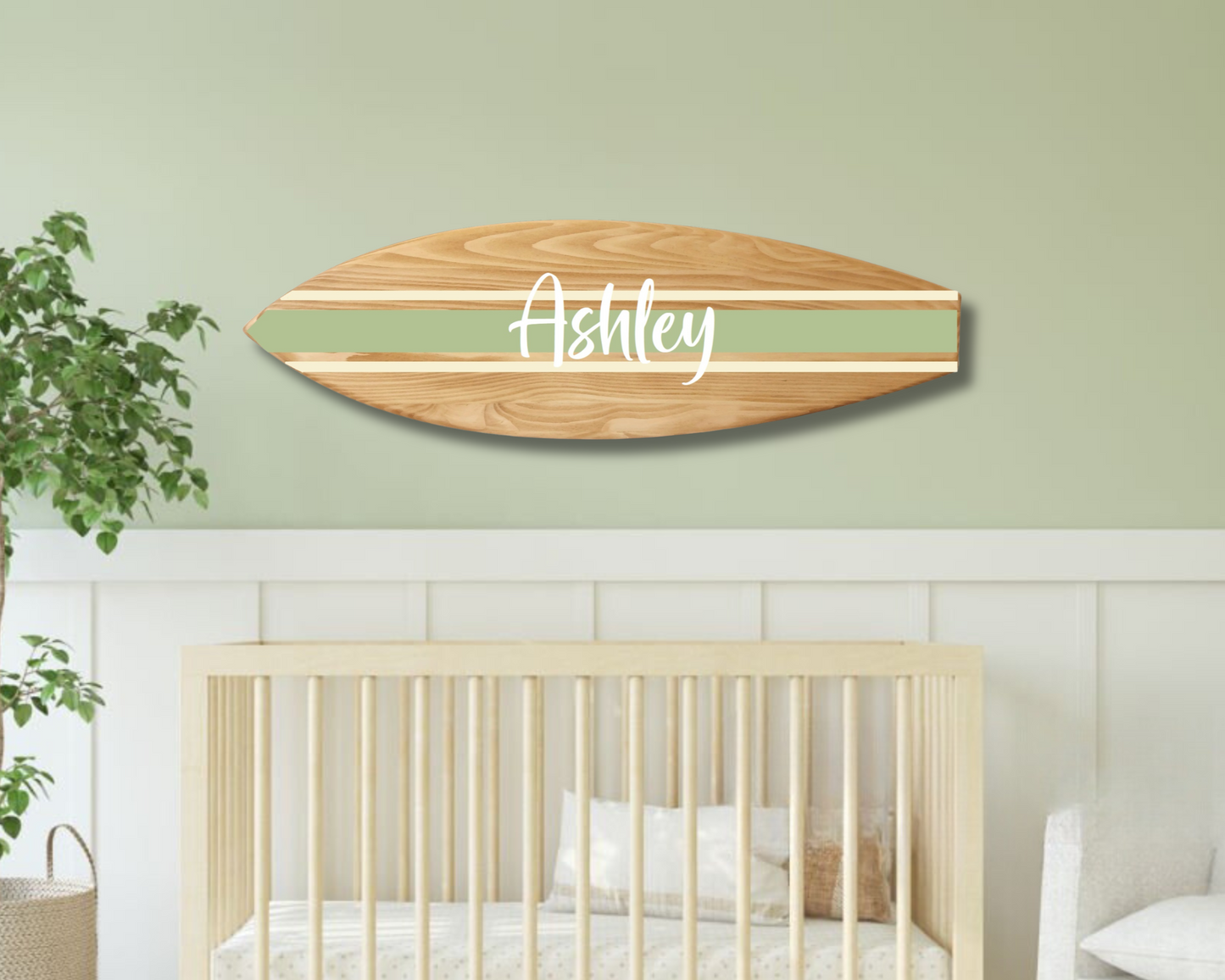 Wooden surfboard name sign hanging in surf-themed nursery