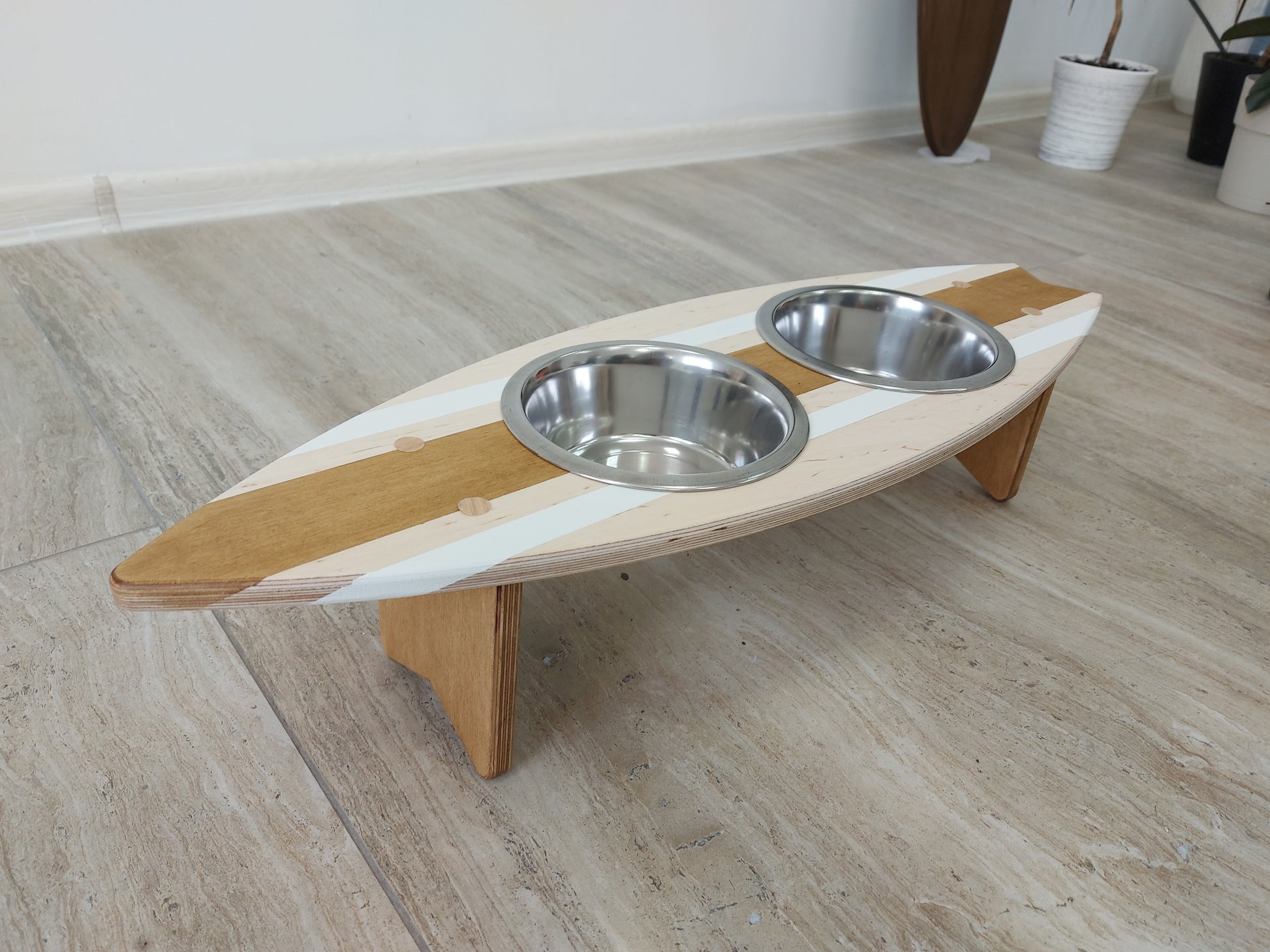 Handmade surfboard pet feeding stand styled in a coastal-inspired room