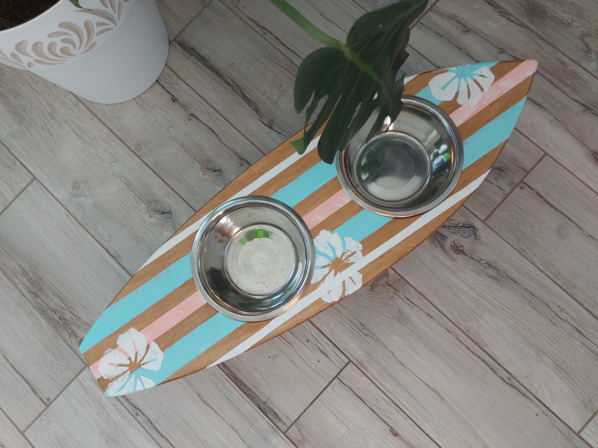 Close-up of custom painting on surfboard pet bowl holder