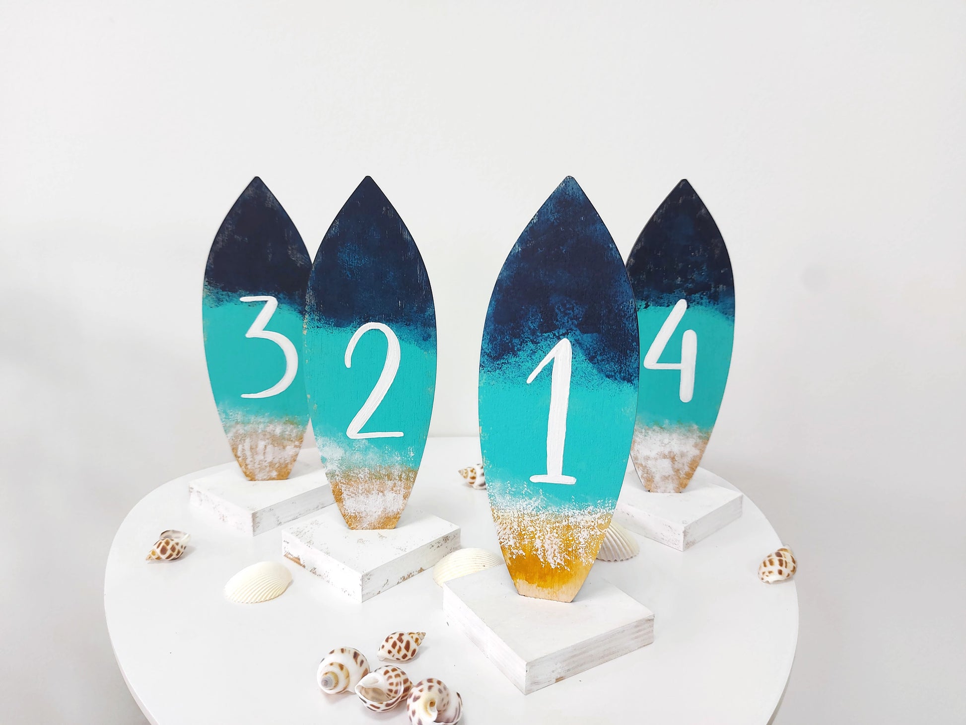Beach wedding décor table numbers with surfboard design