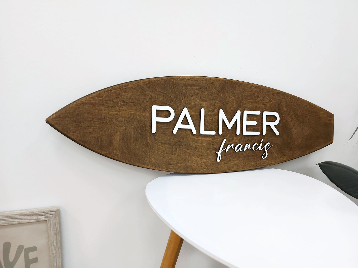 Wooden surfboard name sign displayed in gender-neutral nursery