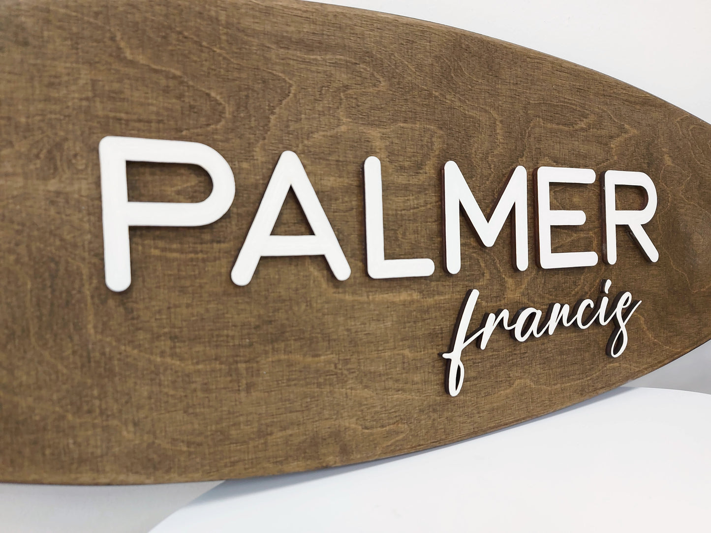 Custom surfboard decor for baby’s room, styled above changing table