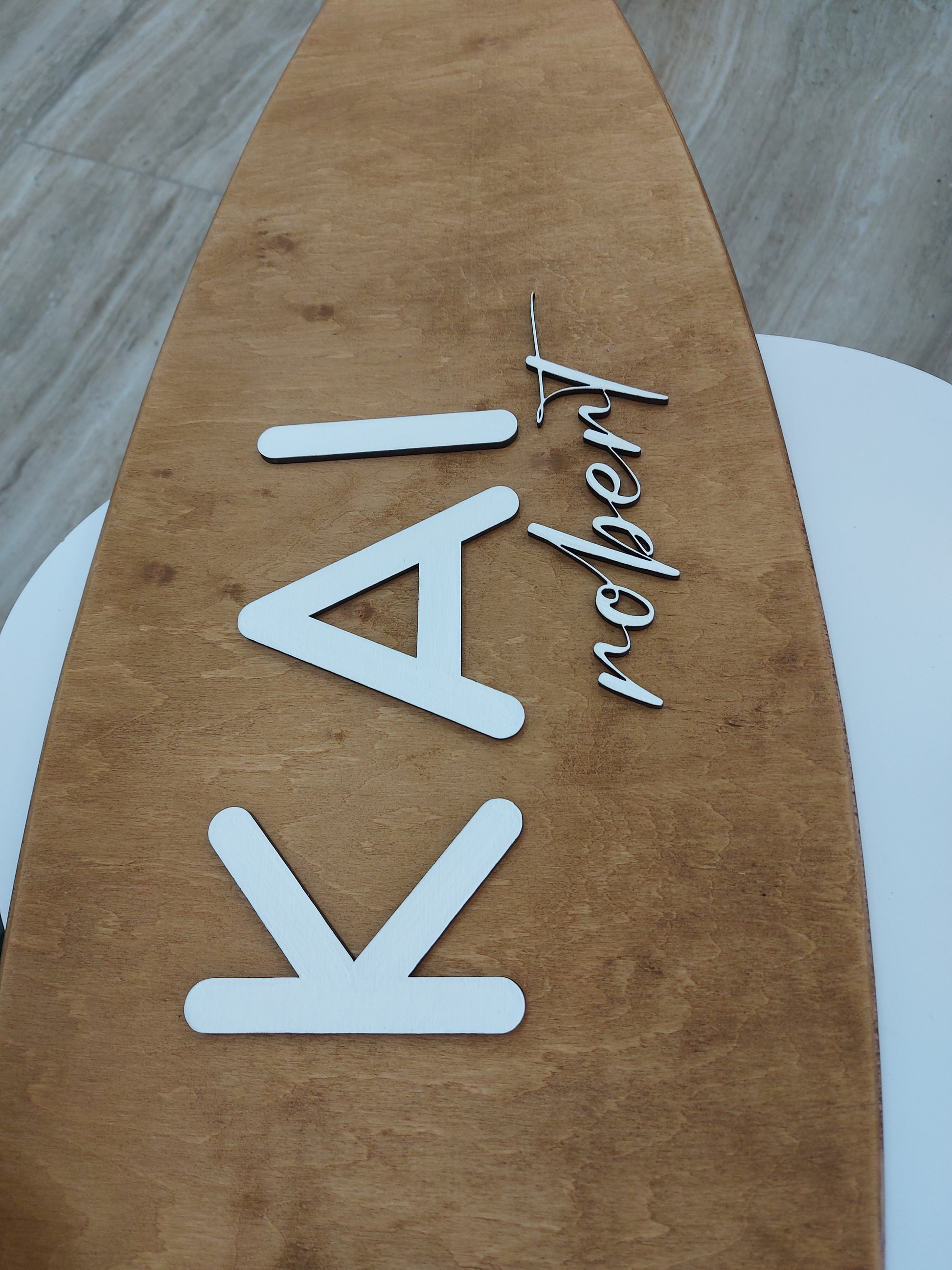 Wooden surfboard nursery name sign with 'KAI' and 'robert' engraved on it