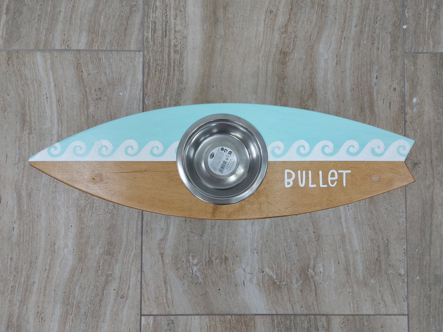 Handmade surfboard pet feeding station styled in coastal home interior