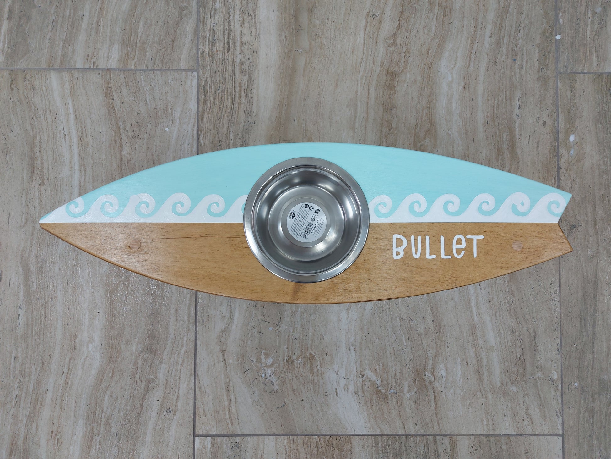 Handmade surfboard pet feeding station styled in coastal home interior