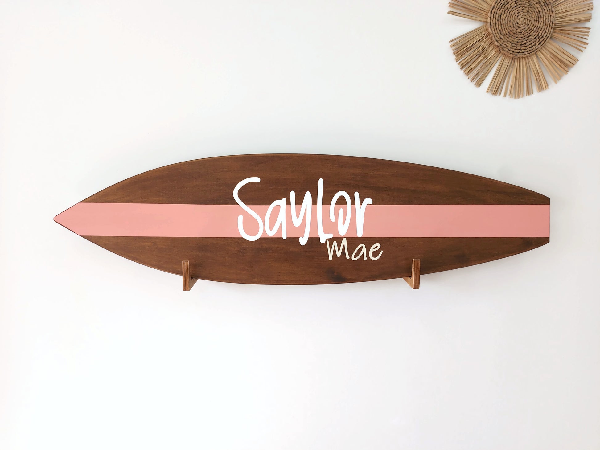 Handmade wooden surfboard decor displayed above crib