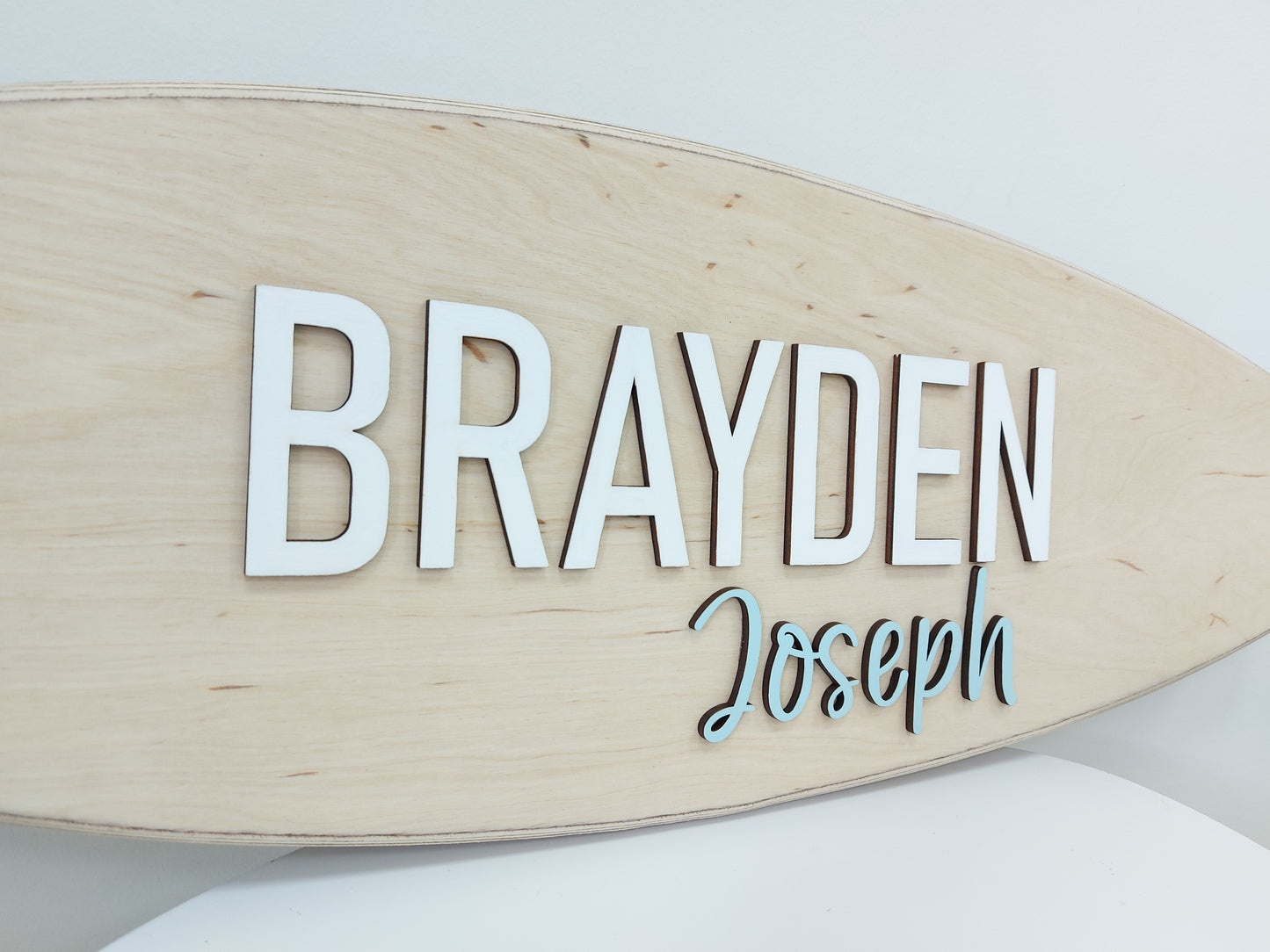 Artisan-made wooden surfboard sign with name in dimensional style