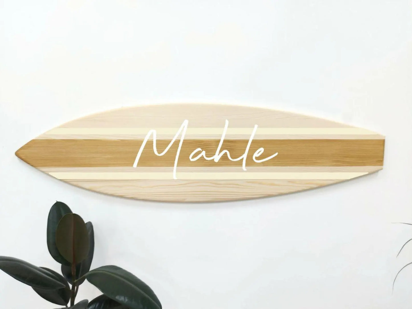 Wooden surfboard-shaped sign with 'Mahle' engraved on a white background