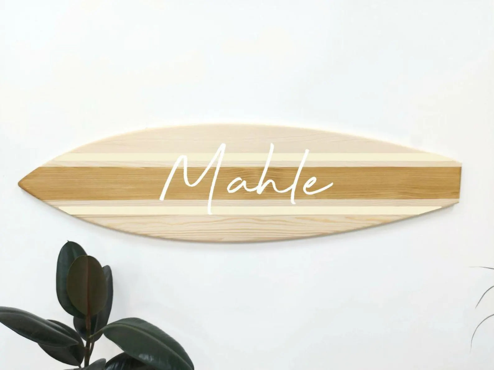 Wooden surfboard-shaped sign with 'Mahle' engraved on a white background