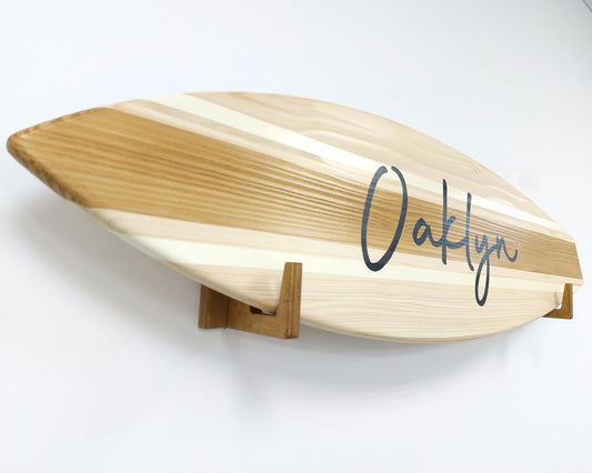 Personalized wooden surfboard name sign hanging on a wall in a nursery room