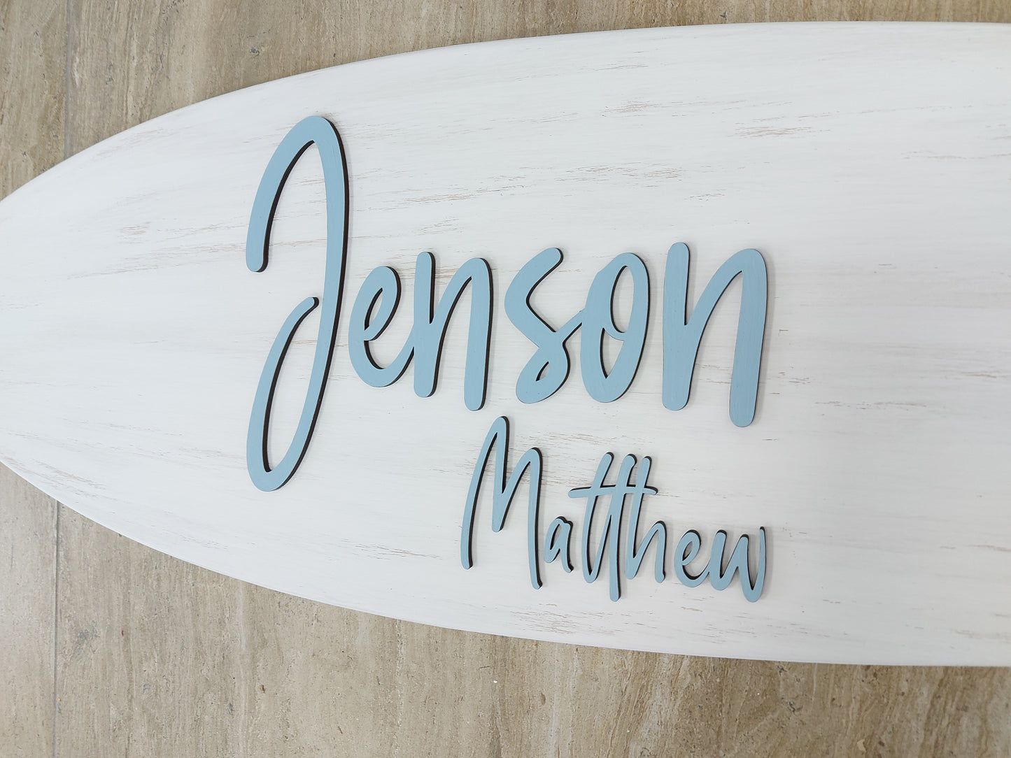 Detail of engraved name on handmade surfboard nursery sign