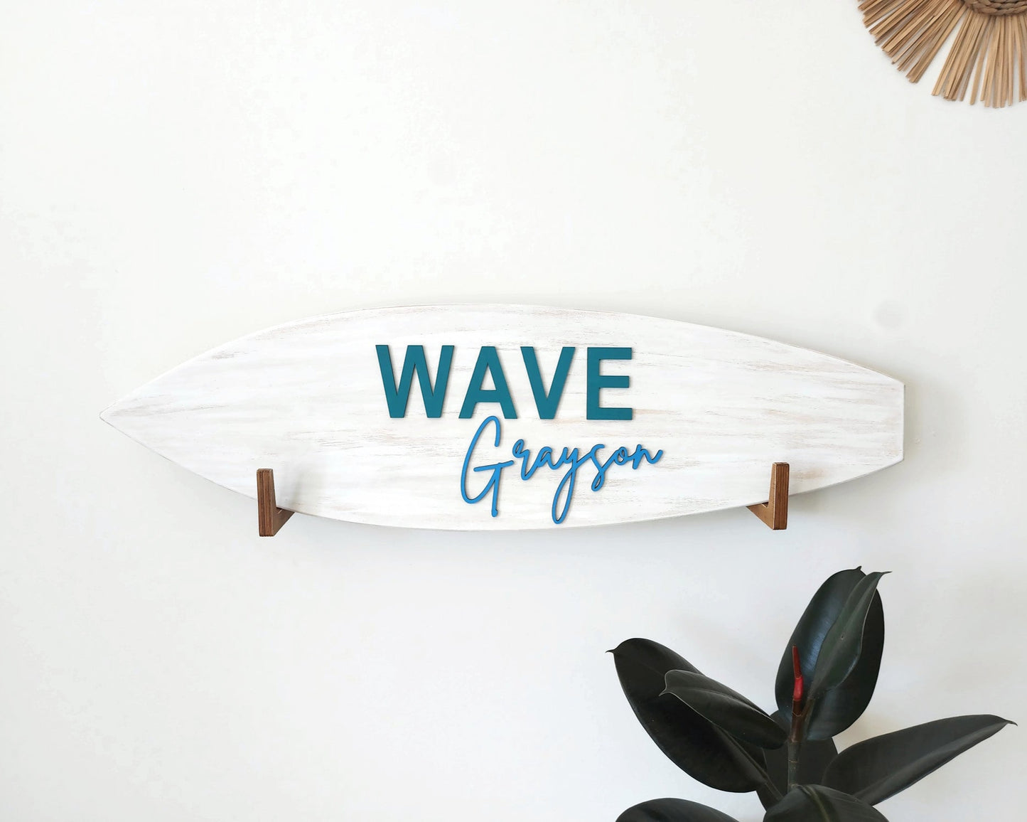 Personalized surfboard name sign hanging in baby nursery above crib