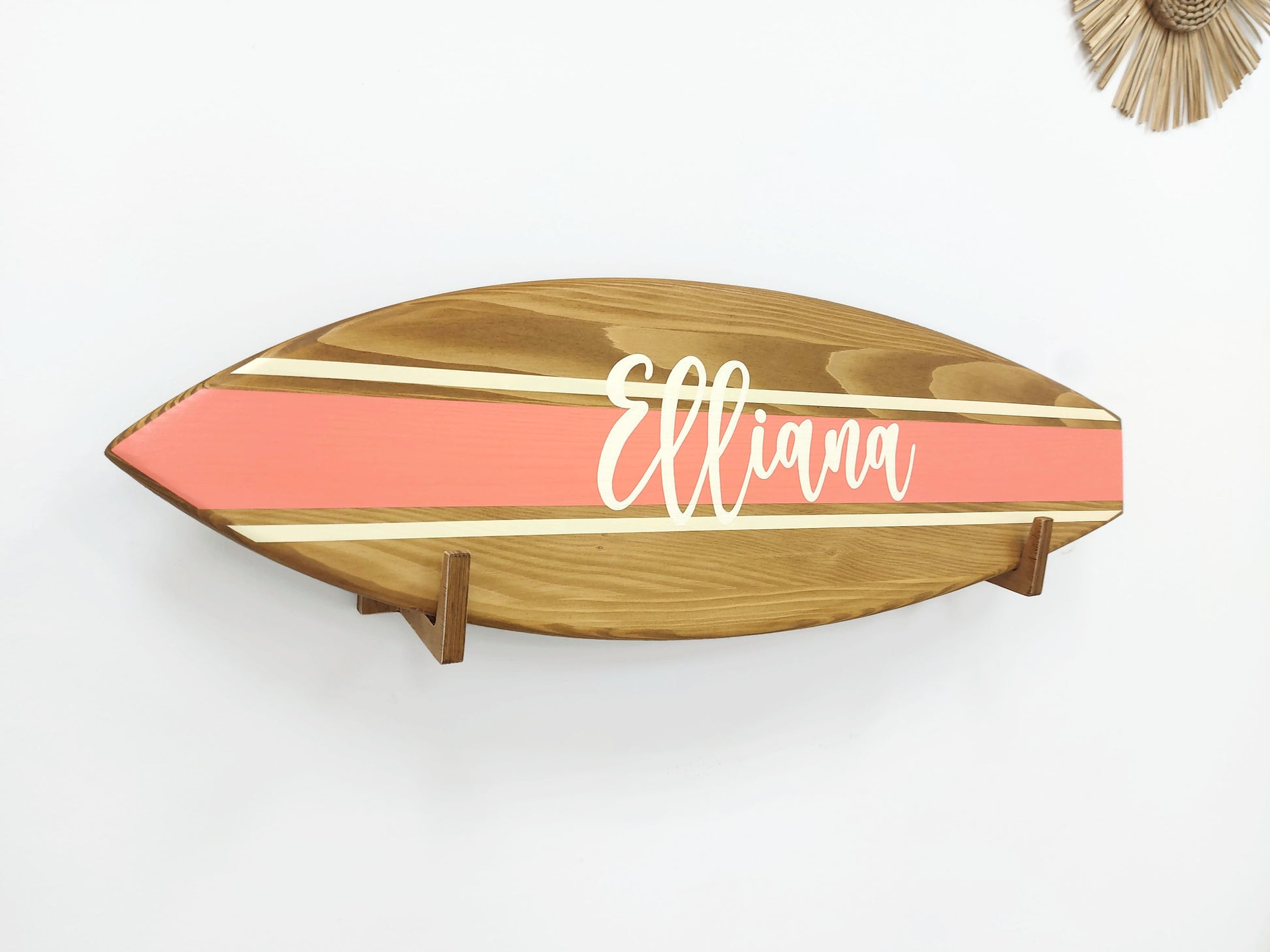 Close-up of engraved name on natural wood surfboard decor