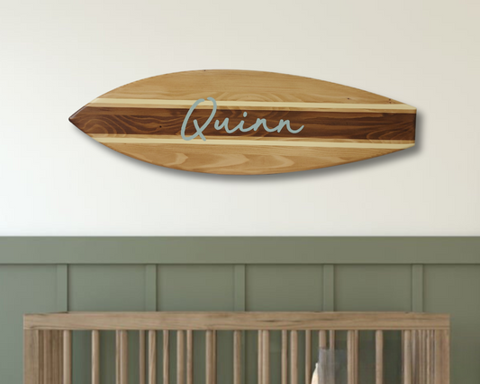 Personalized wooden name sign hanging above baby crib in nursery