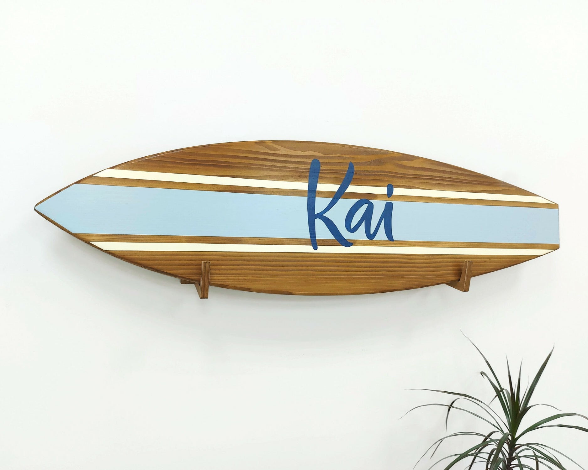 Personalized wooden surfboard name sign hanging in nursery room
