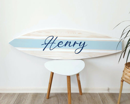 Custom wooden surfboard name sign displayed on nursery wall