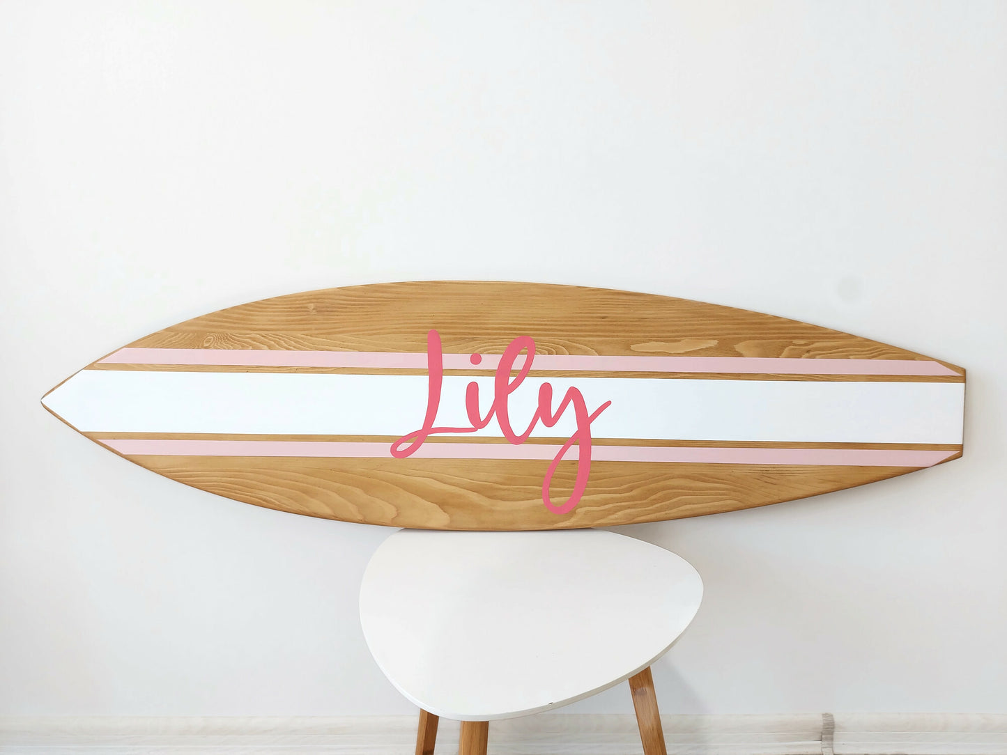 Handcrafted surfboard nursery sign styled in beach-inspired room