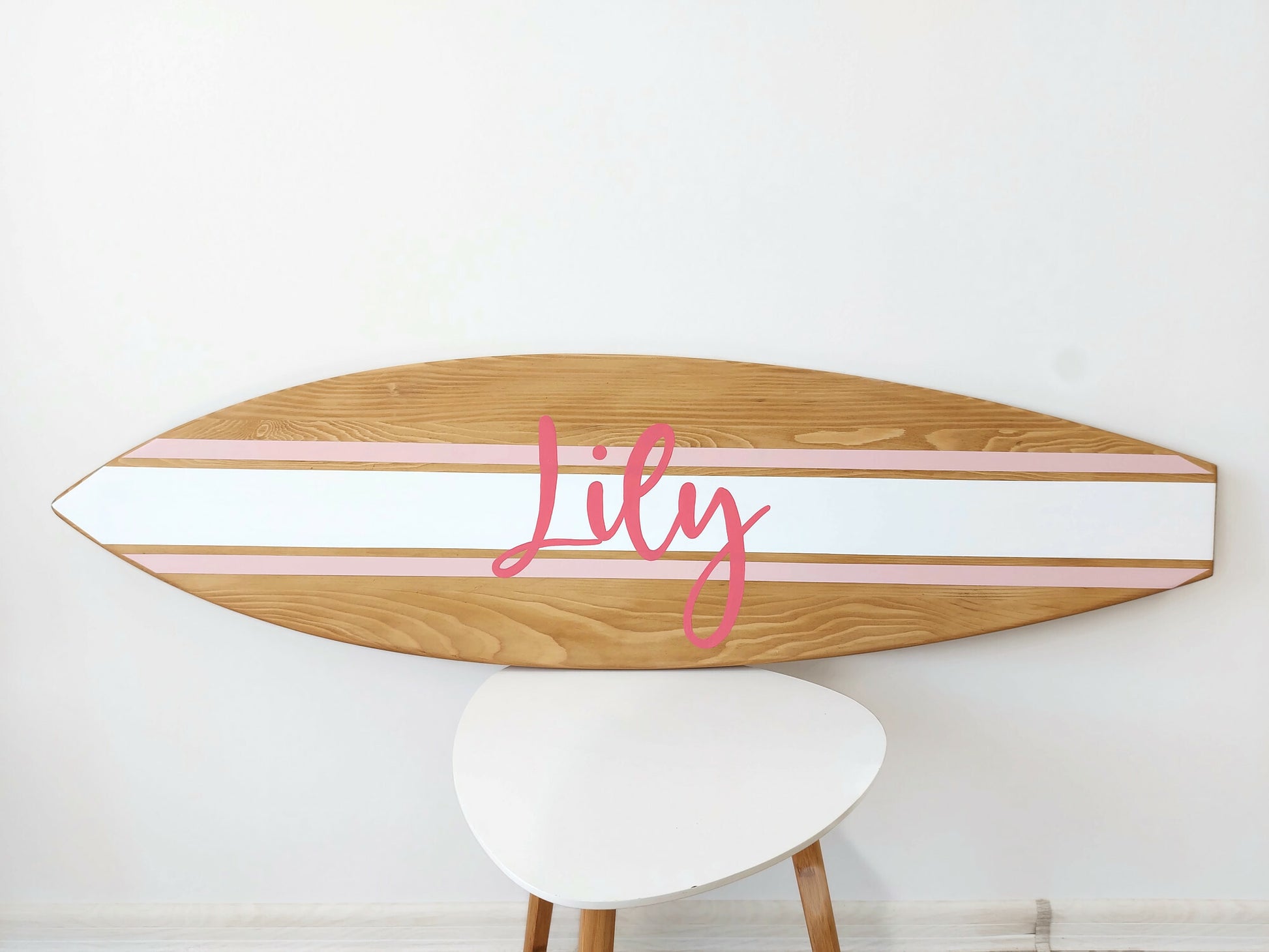 Handcrafted surfboard nursery sign styled in beach-inspired room