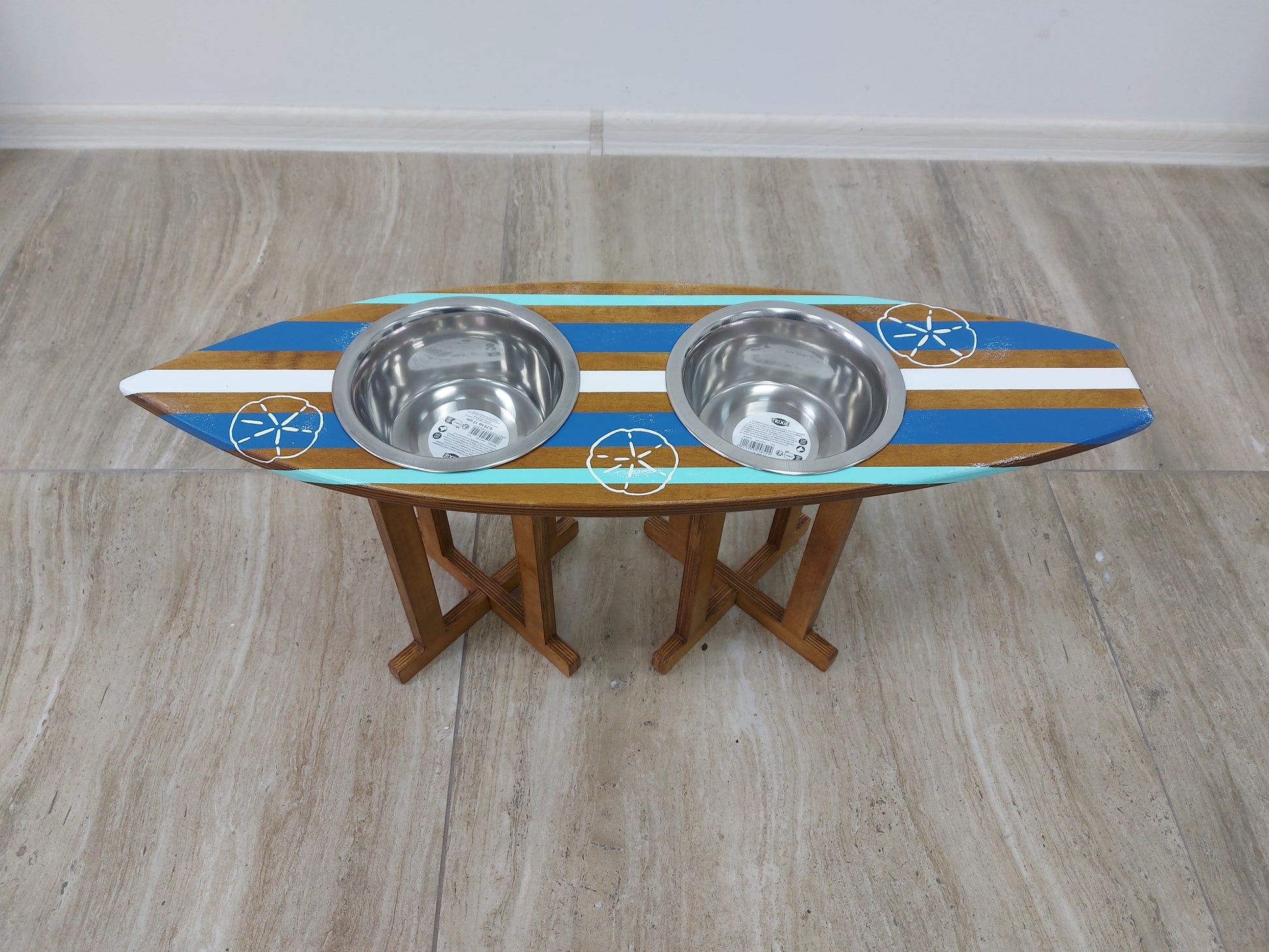 Wooden bowl holder in surfboard shape holding stainless pet bowls