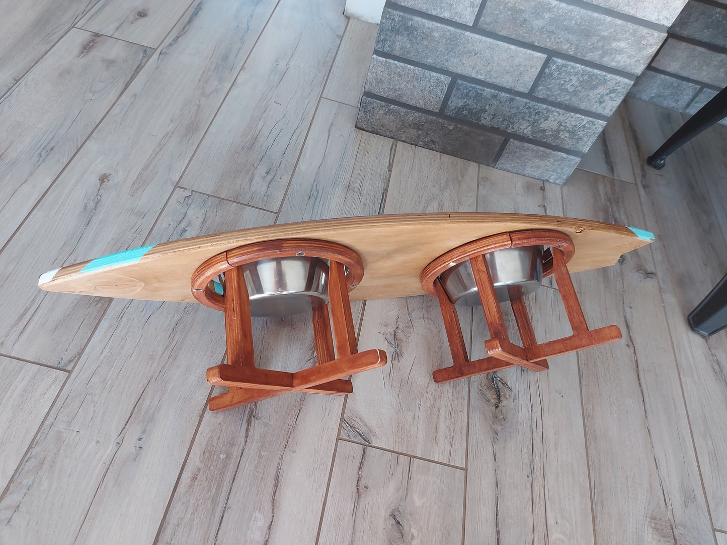 Handmade wooden surfboard pet bowl stand placed on floor ready for food