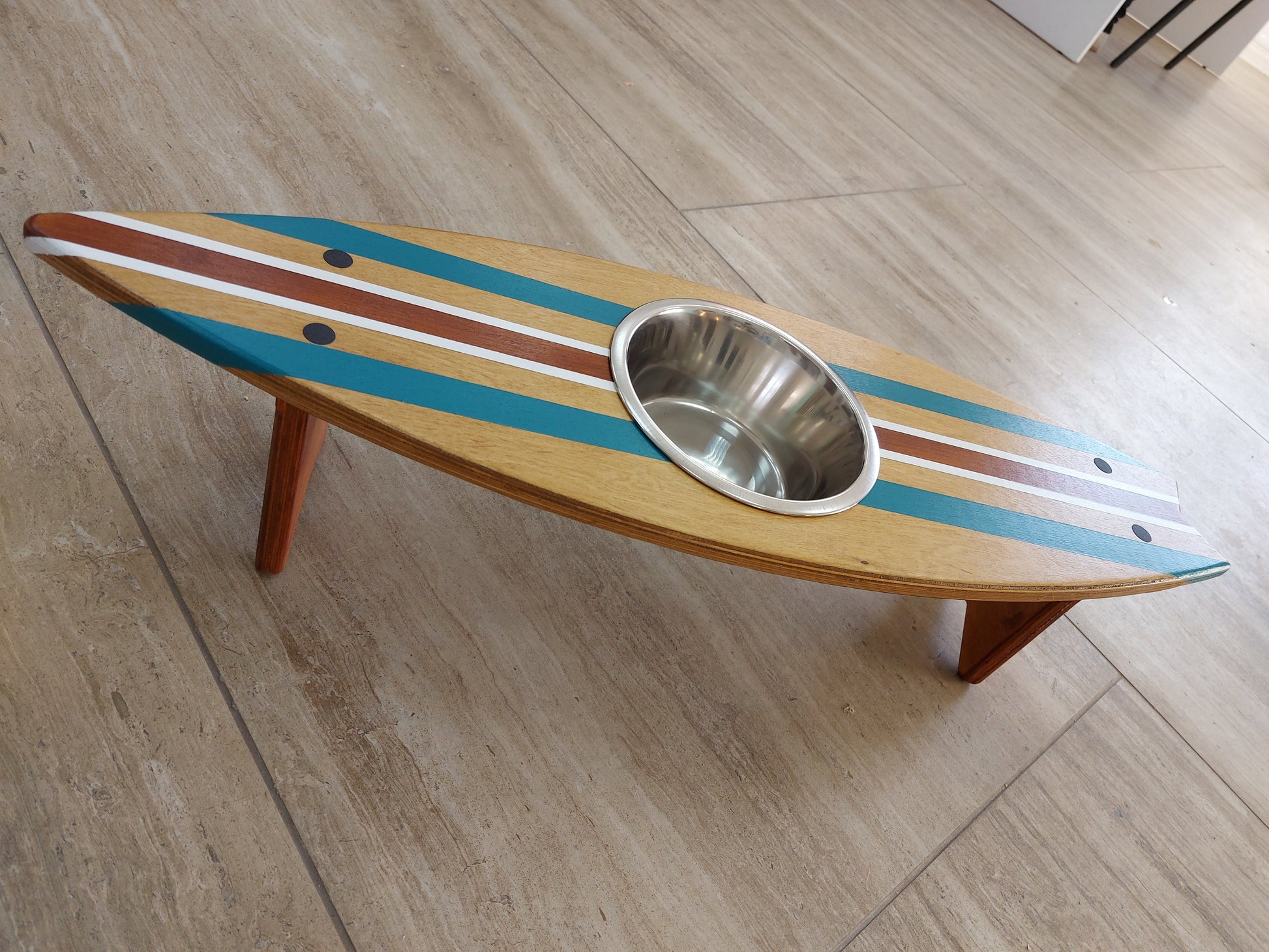 Handmade surfboard pet feeder styled in coastal home interior