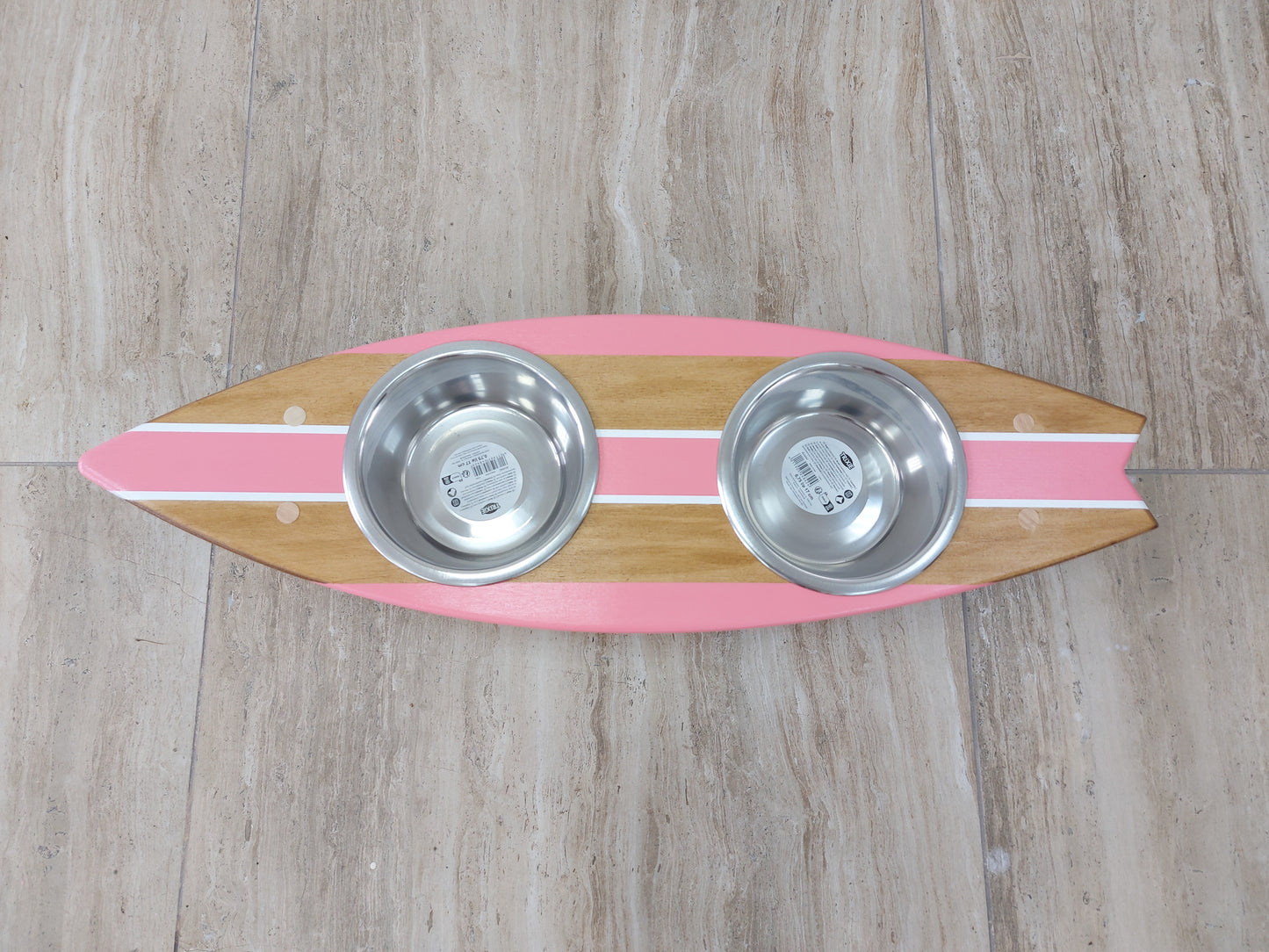Wooden surfboard pet stand holding stainless food and water bowls