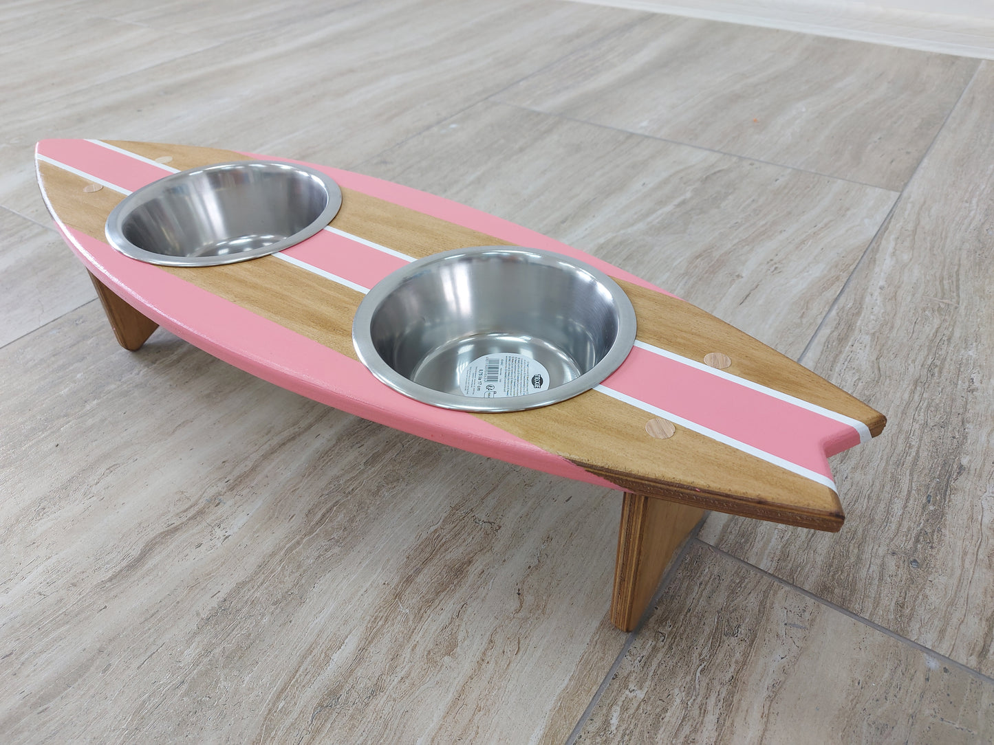 Handmade surfboard pet bowl station styled in coastal home interior