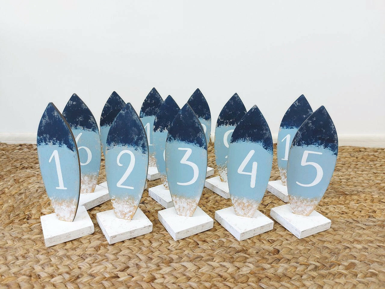 Set of surfboard decorative number signs with blue and white gradient on a textured surface.