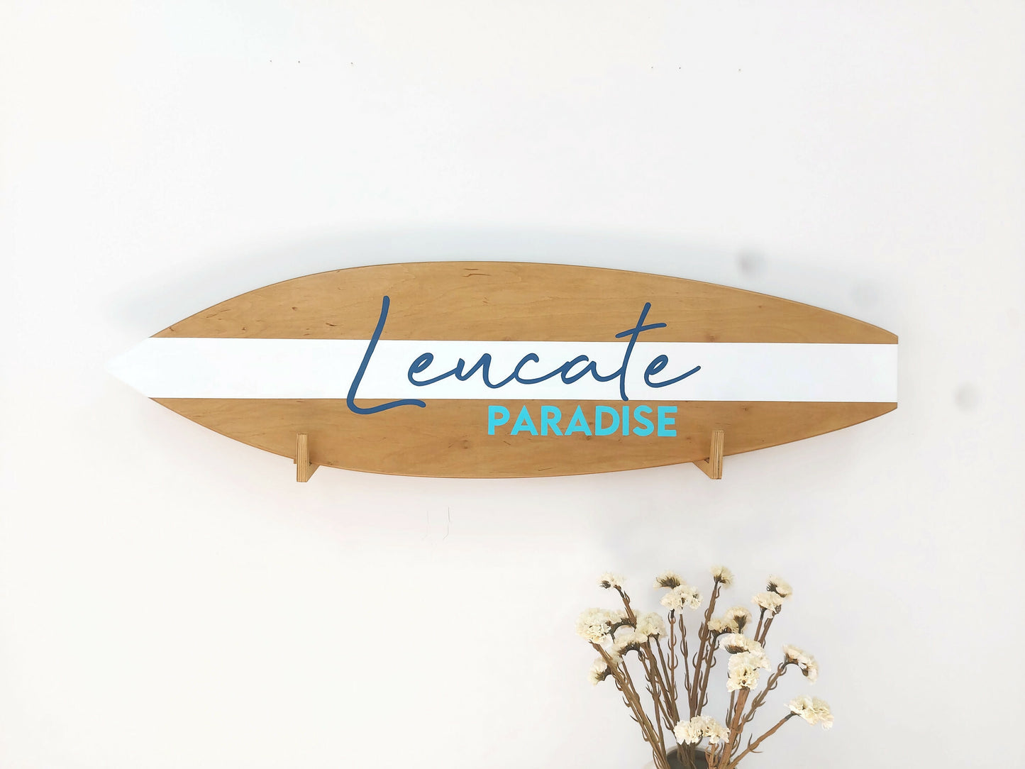 Close-up of engraved name on custom wooden surfboard decor