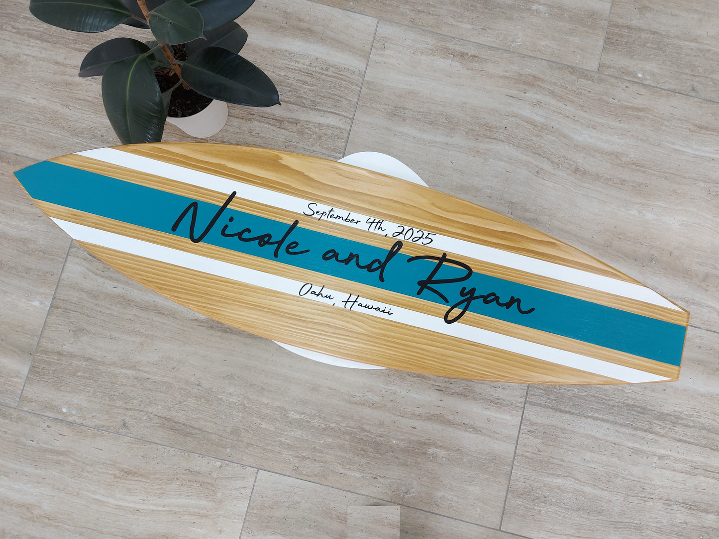 Guests signing surfboard guest book at wedding