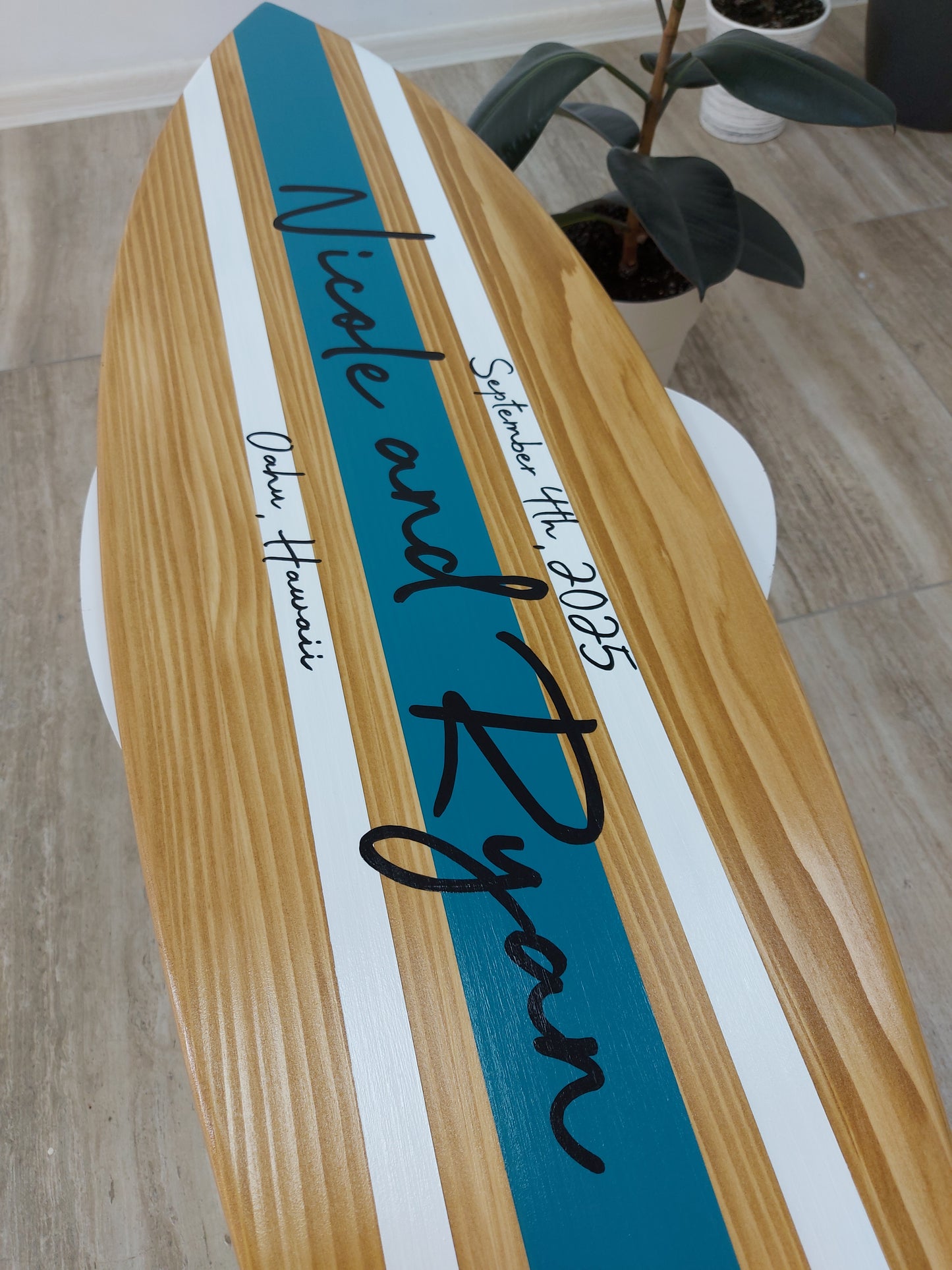 Surfboard guest book alternative displayed at wedding reception
