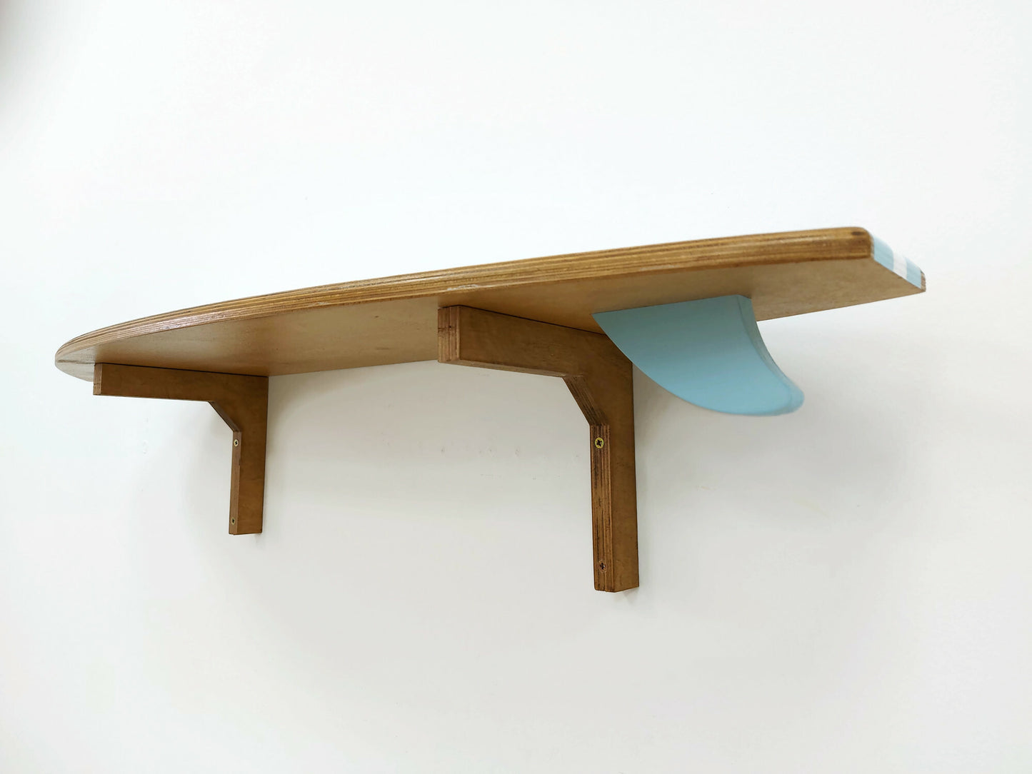 Surfboard-shaped wooden shelf wall décor in coastal interior