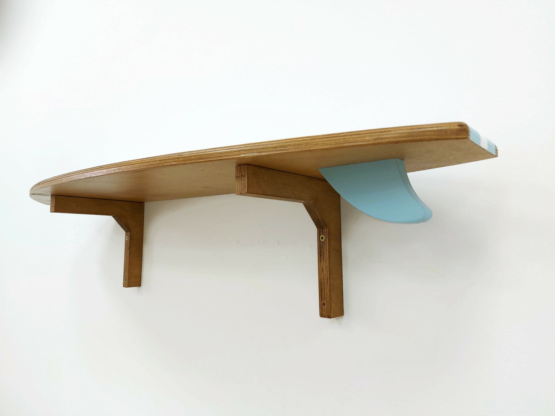 Surfboard-shaped wooden shelf wall décor in coastal interior