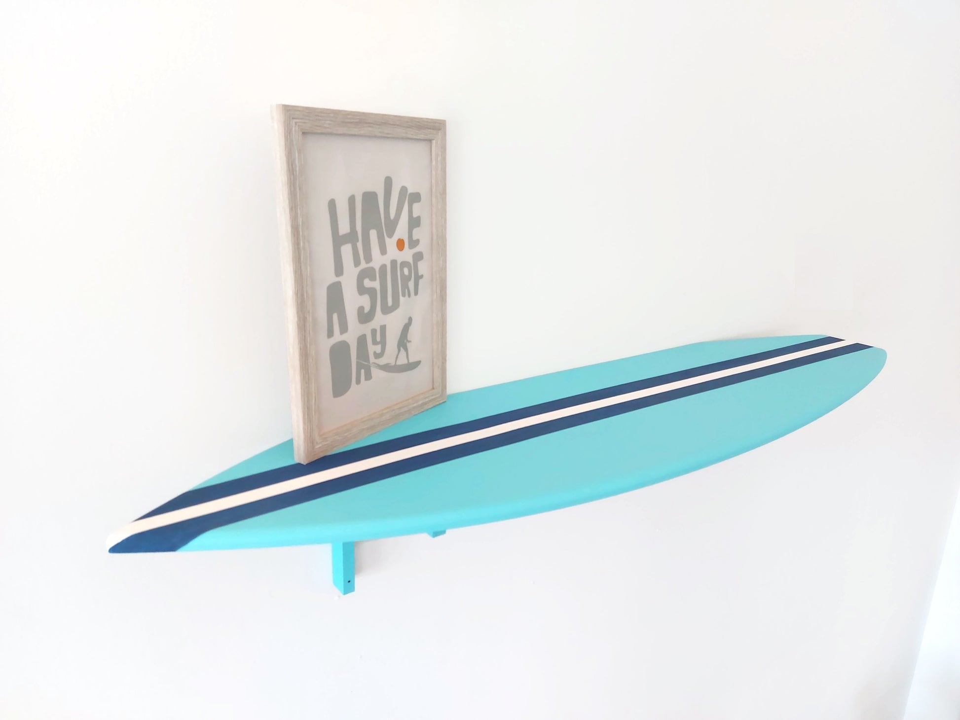 Surfboard-shaped wooden shelf in coral and blue coastal wall decor