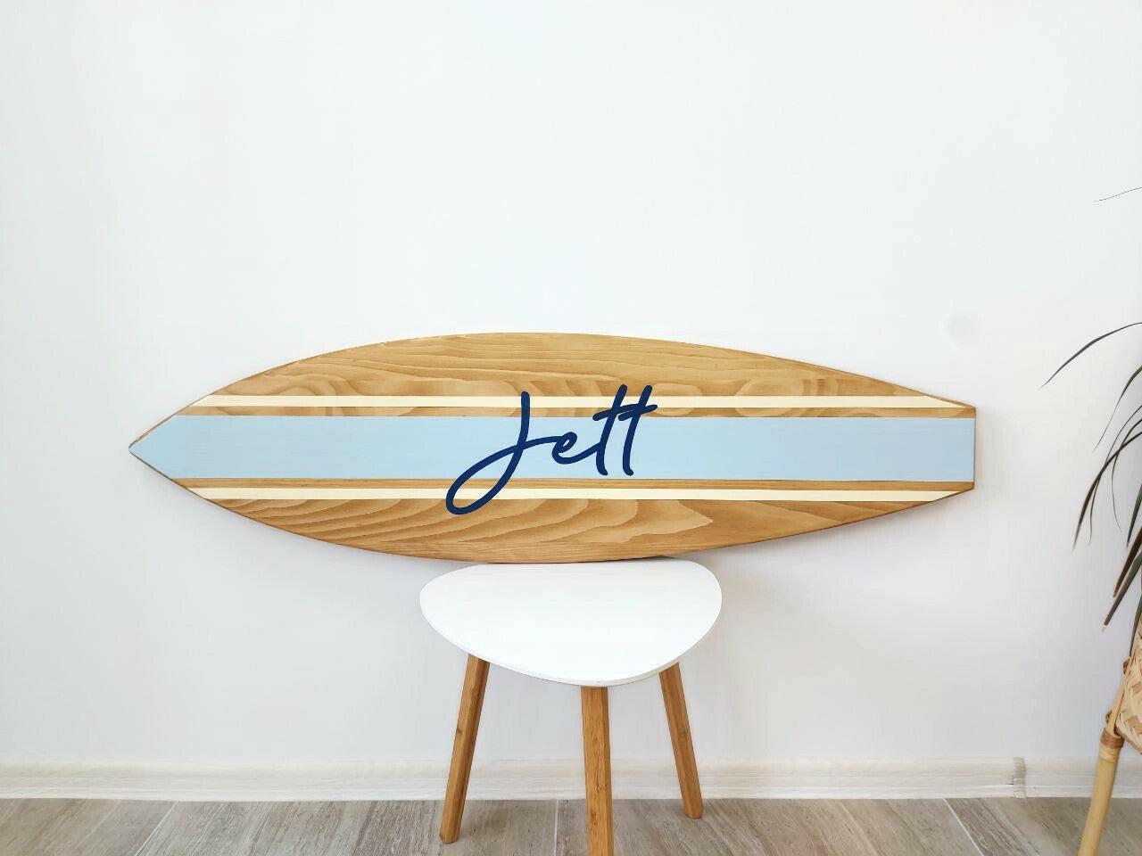 Coastal-inspired baby name plaque hanging above white crib