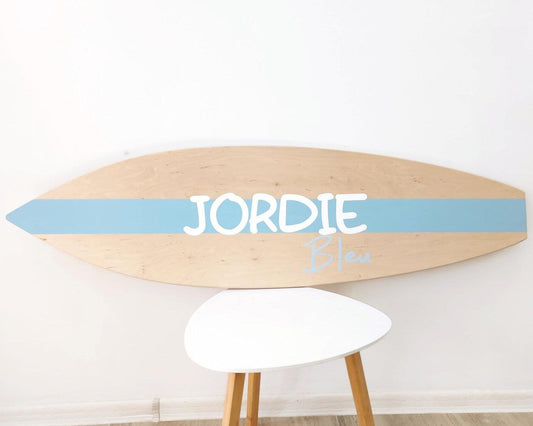 Wooden personalized surfboard baby name sign hanging in nursery