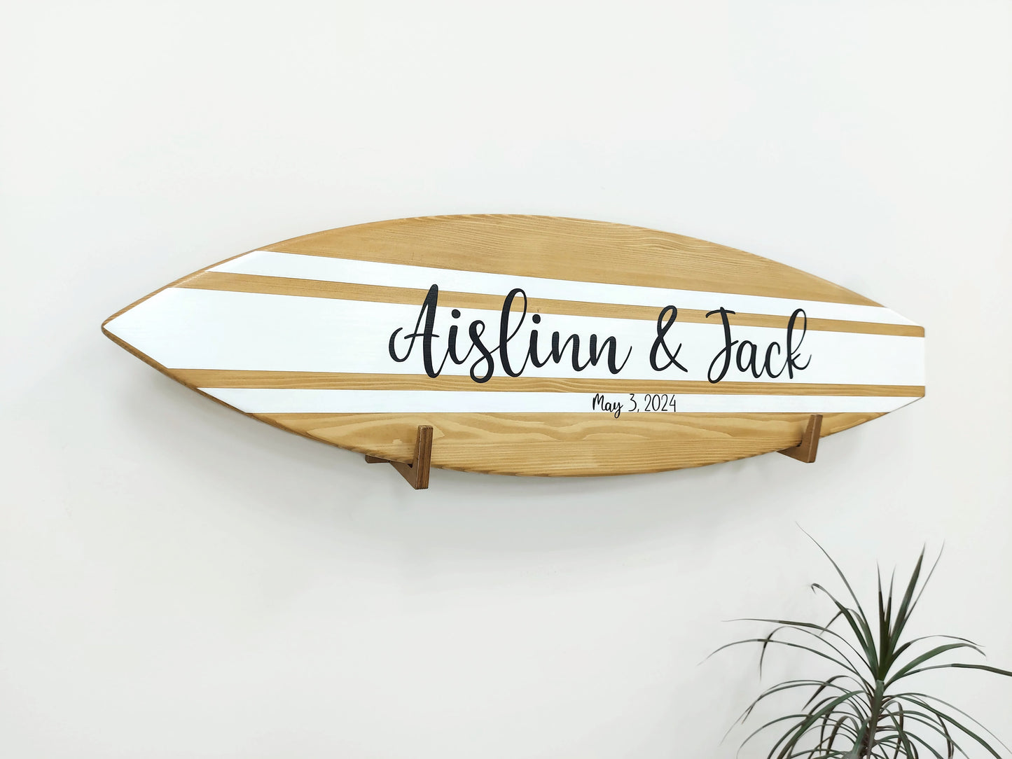 Guests signing wooden surfboard alternative guest book at wedding