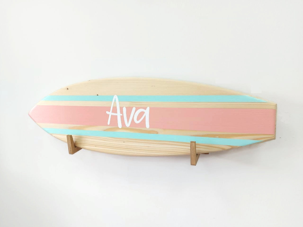 Artisan creating personalized wooden surfboard name sign by hand