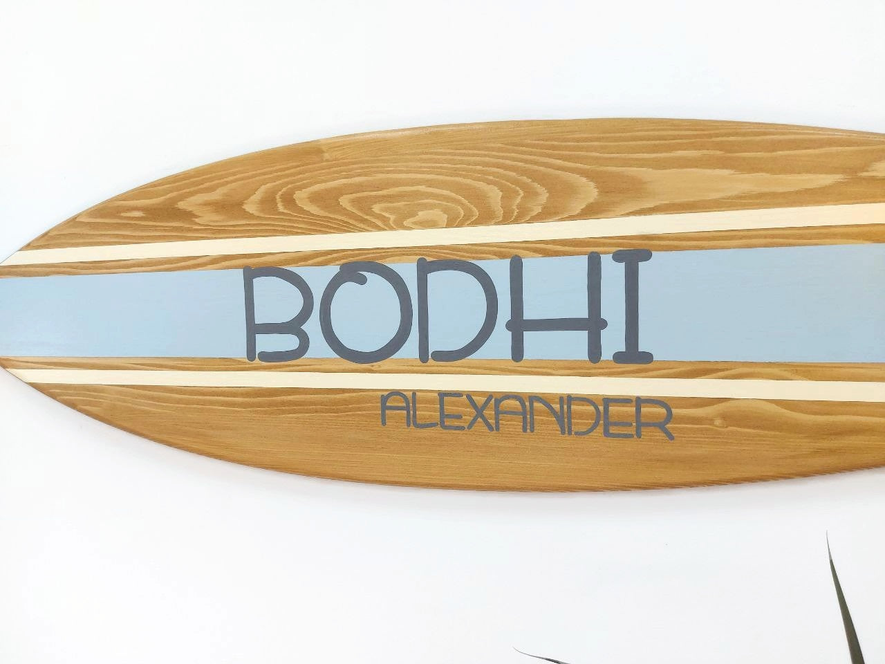 Handcrafted surfboard name sign displayed in coastal-themed kids’ room