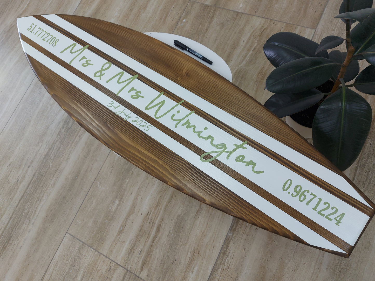 Surfboard guest book alternative displayed at wedding reception