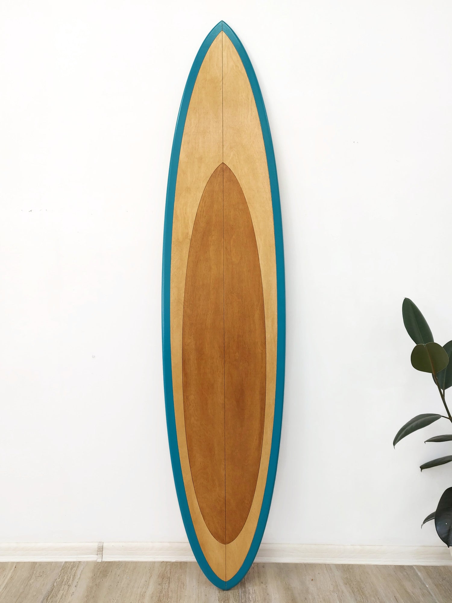 Wooden surfboard wall art with teal trim, front view showing natural wood grain